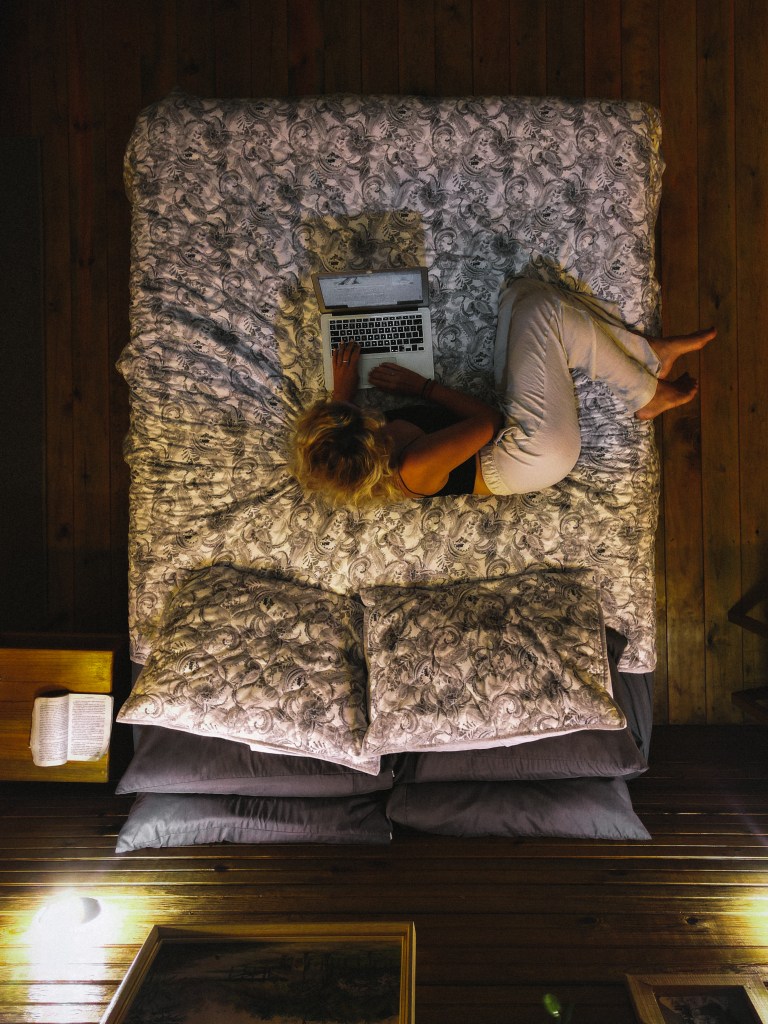 Woman laying on bed with laptop